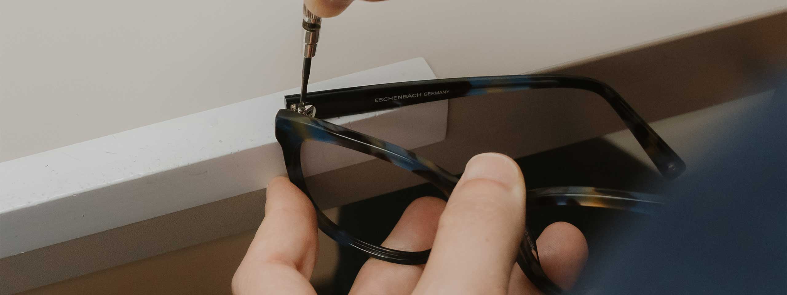 Service bei Optik Scheere, Brille wird in der Hand gehalten