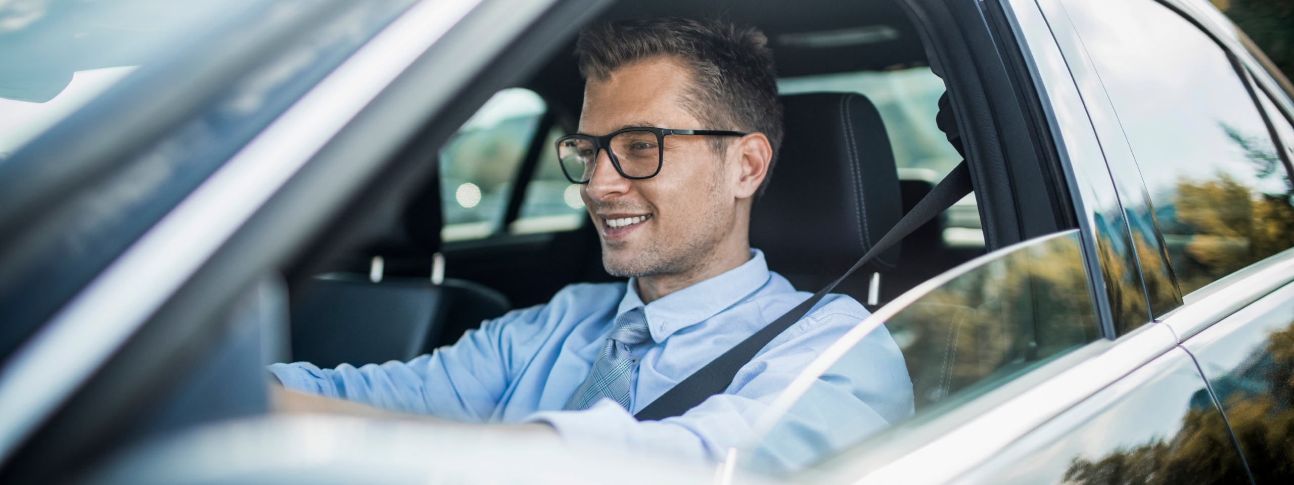 Autofahrerbrille: Mann mit Brille sitzt im Auto und freut sich