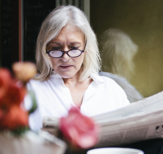 Lesebrille: Ältere Frau liest Zeitung