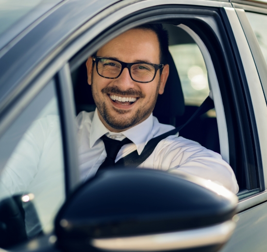 Autofahrerbrille: Mann mit Brille sitzt im Auto und freut sich