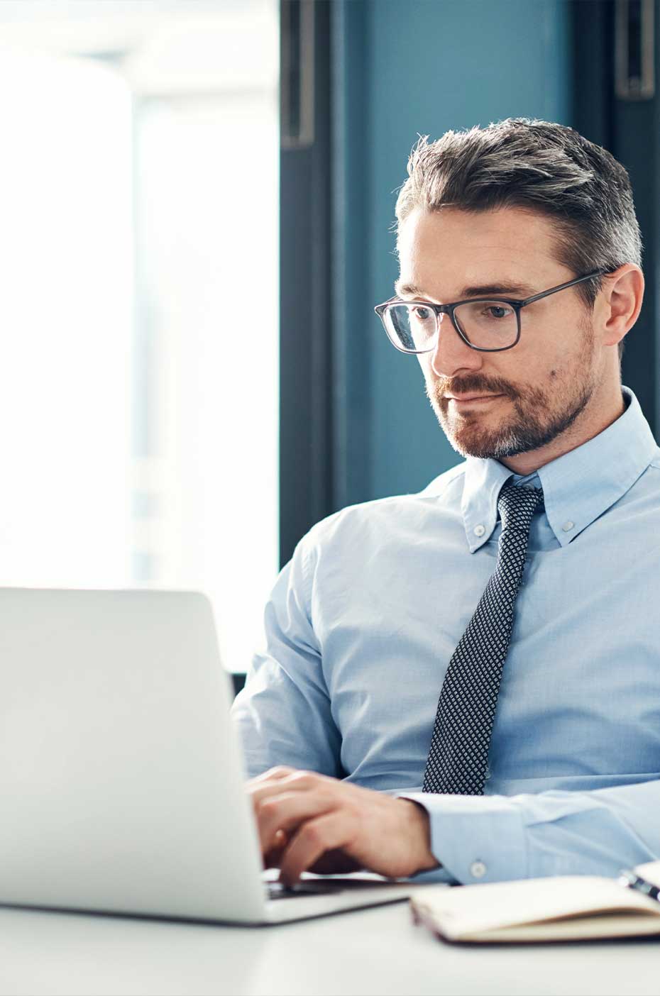 Mann mittleren Alters mit Brille am Computer