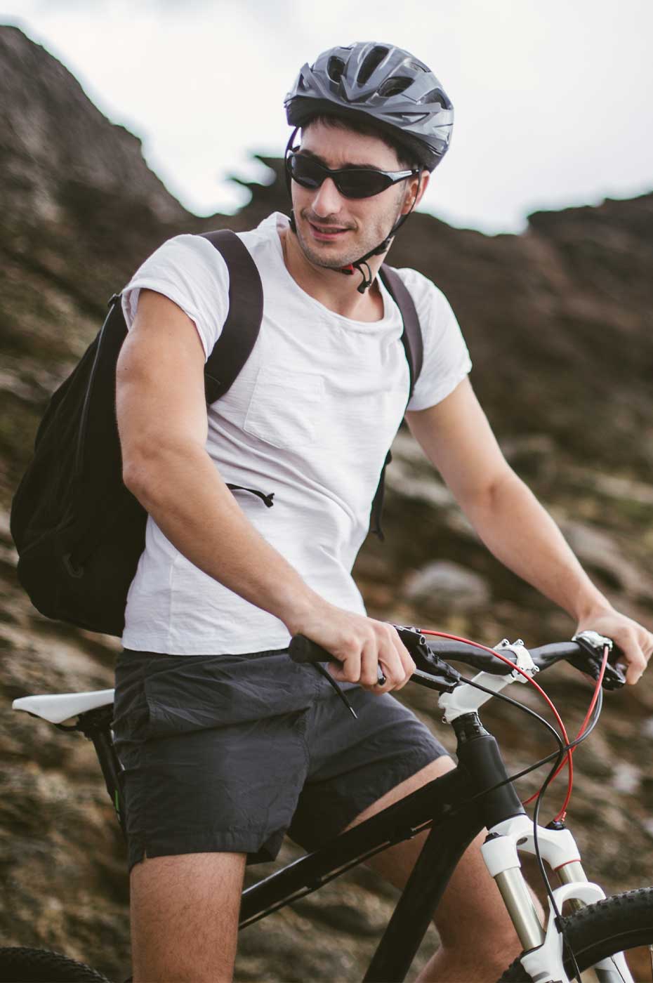 Mann mit Sportbrille auf dem Mountainbike